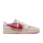 Angled view of Travis Scott Jordan 1 Low Tropical Pink showing pink suede upper and signature reverse swoosh